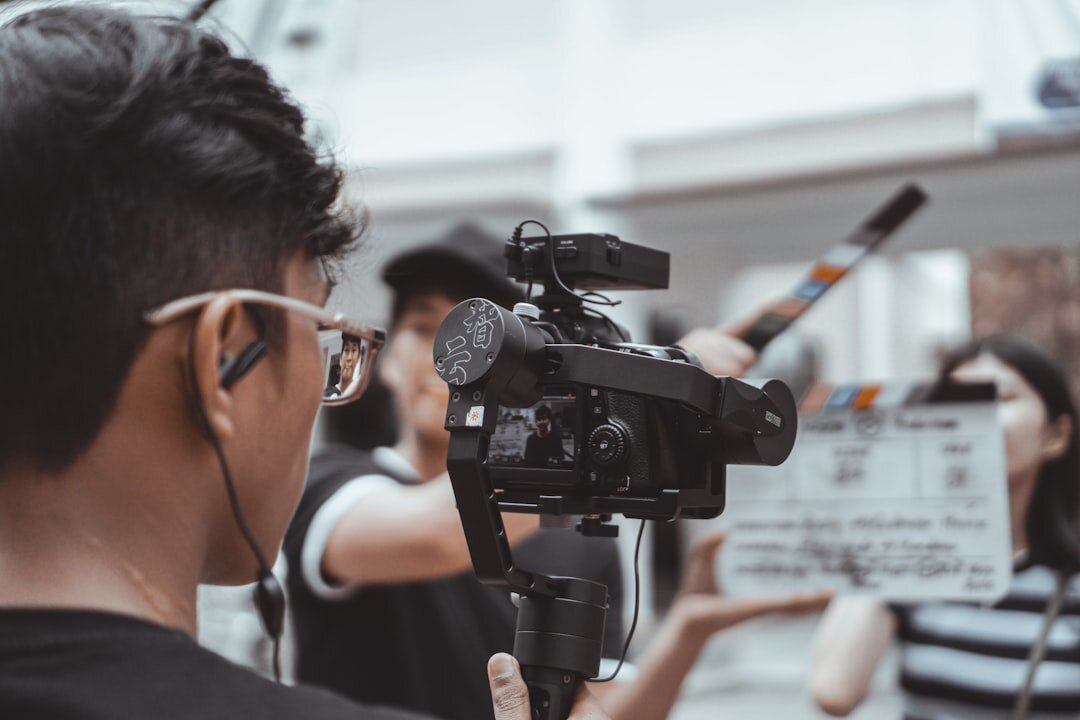 Camera operator filming live production on shoulder